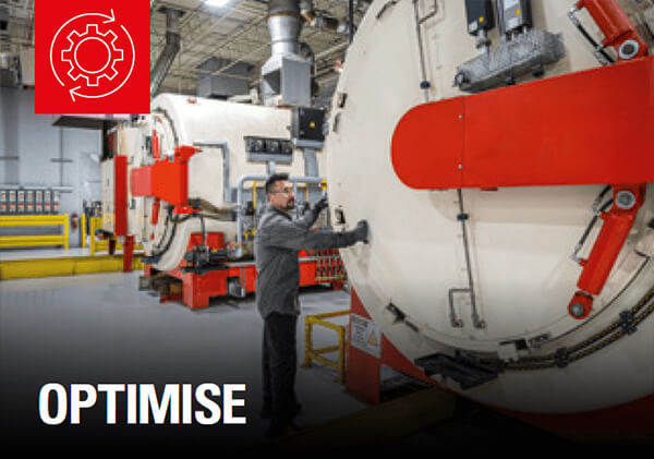 Person operating large, round machine with red handles in industrial facility; "OPTIMISE" at bottom, red gear and arrow icon top left.
