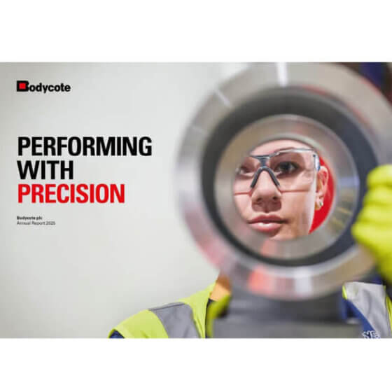 Person in safety glasses and hi-vis jacket peers through large metal ring; text: “Bodycote. Performing with Precision. 2023 Annual Report.”.